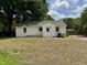 Back of house with white painted brick, door, and ample yard space at 3804 Cobb St, Garner, NC 27529