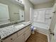 Bright bathroom with a granite countertop vanity and a shower-tub combination at 3804 Cobb St, Garner, NC 27529