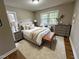 Stylishly staged bedroom with hardwood floors, large windows, and neutral tones at 3804 Cobb St, Garner, NC 27529