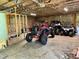 View of spacious garage with three off-road vehicles and partially insulated walls at 3804 Cobb St, Garner, NC 27529