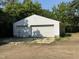 Detached two-car garage with dual doors, white siding, and mature trees in the background at 3804 Cobb St, Garner, NC 27529