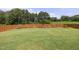 A well-maintained backyard features a lush lawn, mature trees, and a classic wood fence at 42 Village Walk Dr, Chapel Hill, NC 27517