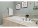 Bathroom featuring a soaking tub with tile surround and sleek fixtures, creating a modern and luxurious space at 42 Village Walk Dr, Chapel Hill, NC 27517