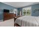 Blue bedroom features wood furniture, large windows and a plush carpet, offering a serene and inviting space at 42 Village Walk Dr, Chapel Hill, NC 27517