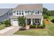 Charming two-story home features a manicured lawn, inviting front porch, and attached two-car garage at 42 Village Walk Dr, Chapel Hill, NC 27517