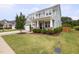 Well-maintained two-story home with a lush green lawn, tidy landscaping, and covered front porch at 42 Village Walk Dr, Chapel Hill, NC 27517