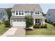 This two-story home boasts a well-kept lawn, two-car garage, and inviting front porch at 42 Village Walk Dr, Chapel Hill, NC 27517