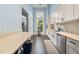 Bright kitchen with white cabinetry, stainless steel appliances, and hardwood floors at 42 Village Walk Dr, Chapel Hill, NC 27517