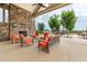 Inviting outdoor living space features a stone fireplace and comfortable seating with views at 42 Village Walk Dr, Chapel Hill, NC 27517