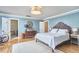 Bedroom with hardwood floors, a decorative mirror, and a bright bathroom in view at 423 N Cameron St, Hillsborough, NC 27278
