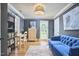 Bedroom with blue sofa, bookshelf, work desk, and natural light at 423 N Cameron St, Hillsborough, NC 27278
