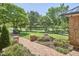 Beautifully landscaped front yard with a brick walkway, mature trees, and well-maintained greenery at 423 N Cameron St, Hillsborough, NC 27278