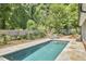 A tranquil in-ground pool with lush landscaping and fenced yard at 423 N Cameron St, Hillsborough, NC 27278