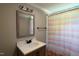 Well-lit bathroom with a framed mirror, neutral walls, modern fixtures, and a patterned shower curtain at 441 Cedar St, Henderson, NC 27536