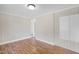 Bright bedroom with durable wood-look floors, painted beadboard walls, and an open doorway at 441 Cedar St, Henderson, NC 27536