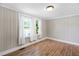Cozy bedroom featuring wood-look flooring, beadboard walls, and natural light from the double windows at 441 Cedar St, Henderson, NC 27536
