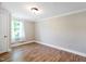Light-filled bedroom featuring updated wood-look floors, neutral walls, and a window with sheer curtains at 441 Cedar St, Henderson, NC 27536