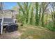 Cozy backyard with an outdoor grill, green grass, and beautiful trees at 4520 Timberhurst Dr, Raleigh, NC 27612