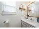 Bathroom with a white vanity, sink, mirror, and window at 4520 Timberhurst Dr, Raleigh, NC 27612