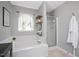 Bright bathroom featuring large soaking tub, step-in shower, and neutral color palette at 4520 Timberhurst Dr, Raleigh, NC 27612