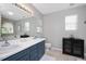 A bathroom with double sinks, a large mirror, a toilet, storage cabinet, and neutral decor at 4520 Timberhurst Dr, Raleigh, NC 27612