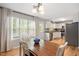 Bright dining area features hardwood floors, large windows, and a view of the kitchen with stainless steel appliances at 4520 Timberhurst Dr, Raleigh, NC 27612