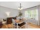 Bright dining room with hardwood floors, a wooden table, and large windows with natural light at 4520 Timberhurst Dr, Raleigh, NC 27612