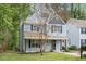 Charming two-story home with light blue siding, black shutters, front porch, and landscaped yard at 4520 Timberhurst Dr, Raleigh, NC 27612