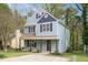 Charming two-story home with light blue siding, black shutters, front porch, and landscaped yard at 4520 Timberhurst Dr, Raleigh, NC 27612