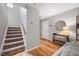 Bright foyer with hardwood floors, staircase, and stylish console table with a round mirror at 4520 Timberhurst Dr, Raleigh, NC 27612