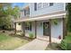 Inviting front porch with rustic wooden columns, hanging plants, and a welcoming wreath on the front door at 4520 Timberhurst Dr, Raleigh, NC 27612