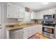 Well-lit kitchen with white cabinets, stainless steel appliances, granite countertops, and hardwood floors at 4520 Timberhurst Dr, Raleigh, NC 27612