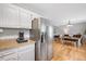Kitchen with stainless steel refrigerator, granite counters, hardwood floors, and adjacent dining area at 4520 Timberhurst Dr, Raleigh, NC 27612