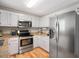 Kitchen with stainless steel appliances, white cabinets, and granite countertops at 4520 Timberhurst Dr, Raleigh, NC 27612
