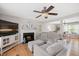 Cozy living room with a fireplace, ceiling fan, hardwood floors, and comfortable seating arrangement at 4520 Timberhurst Dr, Raleigh, NC 27612