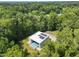 Aerial view of modern house with a pool, nestled in a lush green forest at 4908 Birchleaf Dr, Raleigh, NC 27606