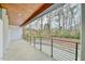 Lovely outdoor balcony with wood ceiling and a black metal railing overlooking a wooded area at 4908 Birchleaf Dr, Raleigh, NC 27606