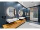 Modern bathroom features floating vanities with round mirrors and black marble accent wall at 4908 Birchleaf Dr, Raleigh, NC 27606