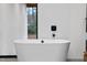 Freestanding white bathtub near a window, offering a serene and spa-like experience at 4908 Birchleaf Dr, Raleigh, NC 27606