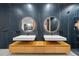Modern bathroom features floating vanities with round mirrors and black marble accent wall at 4908 Birchleaf Dr, Raleigh, NC 27606