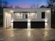 Exterior night view of a modern home featuring a balcony and minimalist design with landscape lighting at 4908 Birchleaf Dr, Raleigh, NC 27606