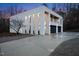 Modern home exterior features an illuminated balcony, a spacious driveway, and well-maintained landscaping at 4908 Birchleaf Dr, Raleigh, NC 27606