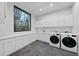 Well-lit laundry room featuring modern appliances, ample counter space and storage cabinets at 4908 Birchleaf Dr, Raleigh, NC 27606
