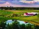 Scenic aerial view of a lush farm landscape with a pond, pastures, and a modern barn, offering tranquility at 5125 Penny Rd, Raleigh, NC 27606
