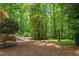 Expansive backyard featuring steps leading to a large grassy area, surrounded by mature trees for privacy at 5125 Penny Rd, Raleigh, NC 27606