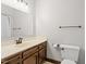 Standard bathroom with wood cabinets, white sink and toilet, and neutral wall color at 5125 Penny Rd, Raleigh, NC 27606