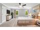Bright bedroom featuring neutral colors, a ceiling fan, and windows overlooking green foliage at 5125 Penny Rd, Raleigh, NC 27606