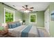 Green bedroom featuring a ceiling fan and abundant natural light at 5125 Penny Rd, Raleigh, NC 27606