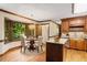 Eat-in kitchen nook featuring wooden cabinets, hardwood floors, a bay window, and a chandelier at 5125 Penny Rd, Raleigh, NC 27606