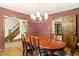 Formal dining room showcasing a large wooden table, chandelier lighting, and staircase access at 5125 Penny Rd, Raleigh, NC 27606